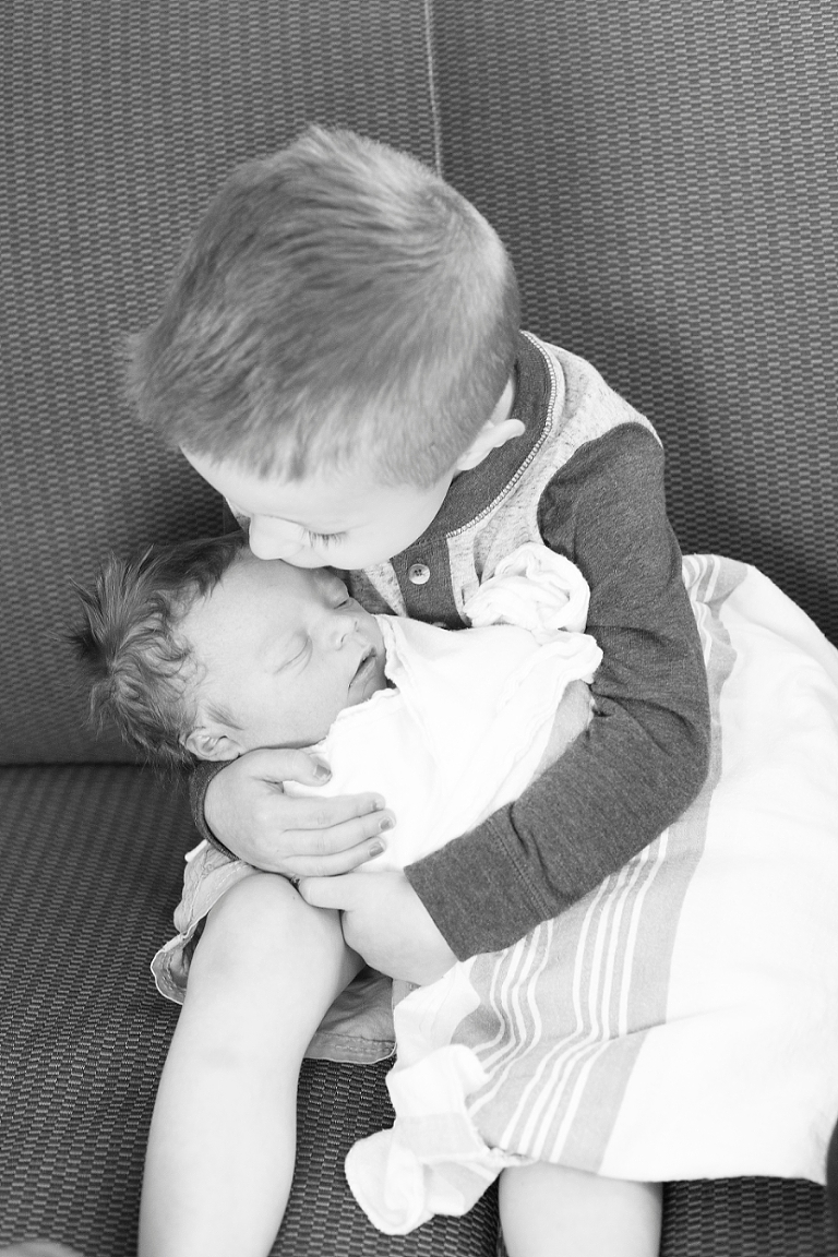 big brother holding his little brother for the first time 