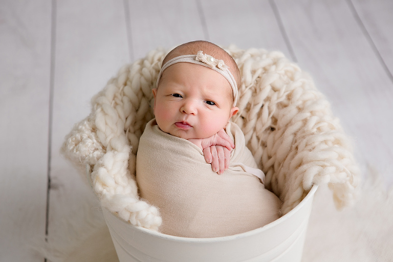newborn baby in white bucket